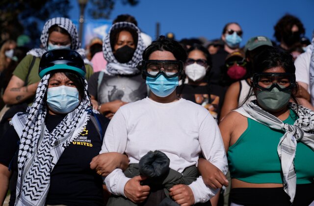 Des manifestants serrent les bras sur le campus de l'UCLA, après des affrontements nocturnes entre groupes pro-israéliens et pro-palestiniens, le mercredi 1er mai 2024, à Los Angeles.  (Photo AP/Jae C. Hong)