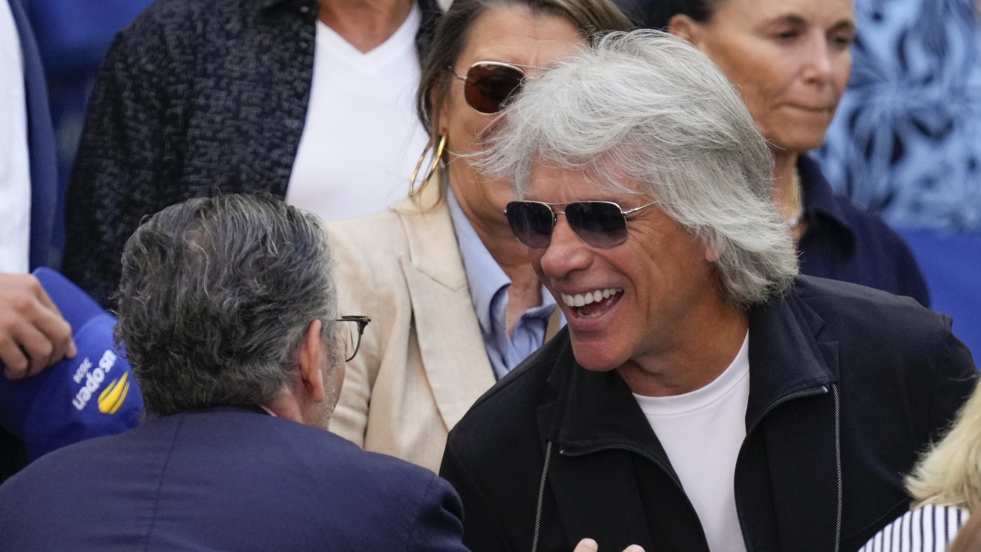 Jon Bon Jovi aide une femme à descendre du bord d'un pont pendant le tournage d'un clip vidéo